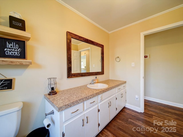 bathroom with hardwood / wood-style floors, vanity, ornamental molding, and toilet