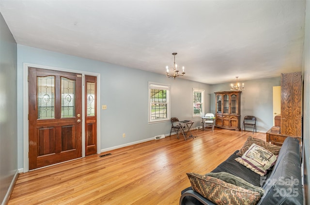 living room with light hardwood / wood-style flooring and an inviting chandelier