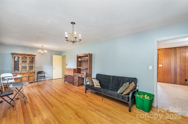 living room featuring light wood-type flooring and an inviting chandelier