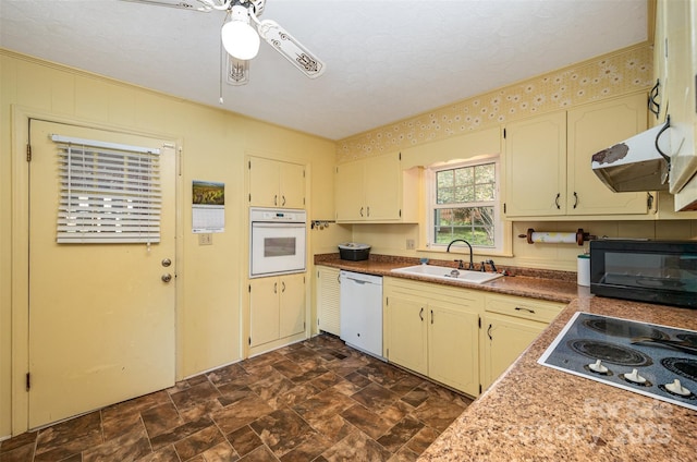 kitchen with ceiling fan, sink, range hood, a textured ceiling, and white appliances