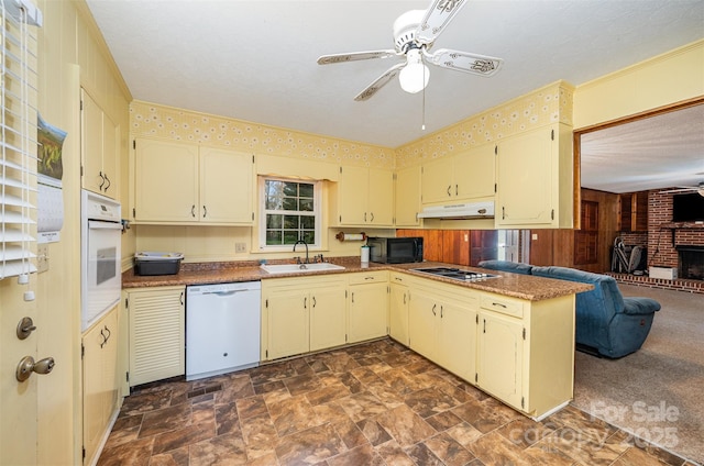 kitchen with a fireplace, white appliances, ceiling fan, and sink