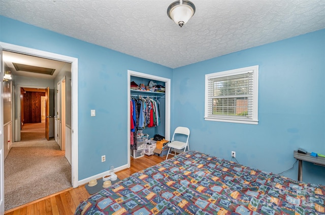 bedroom featuring a textured ceiling, light wood-type flooring, and a closet