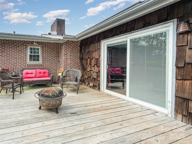 deck with an outdoor living space with a fire pit