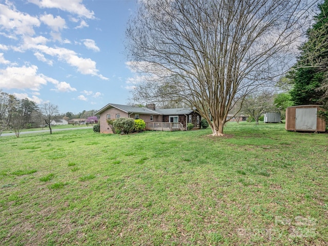 view of yard featuring a storage shed and a deck