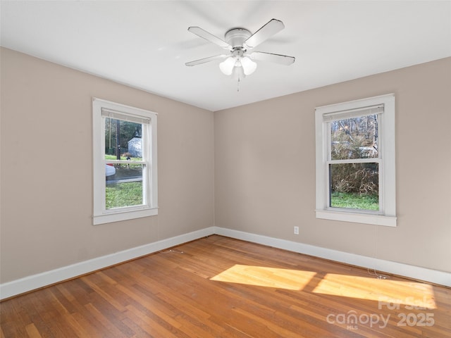 unfurnished room with a wealth of natural light, ceiling fan, and wood-type flooring