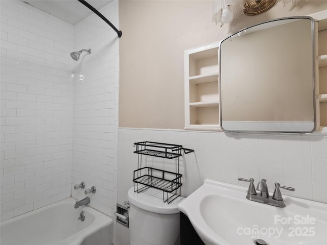 full bathroom with toilet, vanity, tile walls, and tiled shower / bath