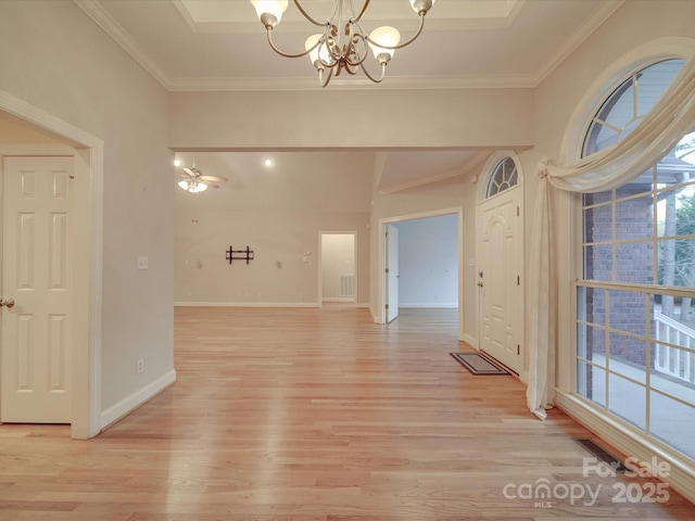 unfurnished room featuring light hardwood / wood-style flooring, a healthy amount of sunlight, ceiling fan with notable chandelier, and ornamental molding