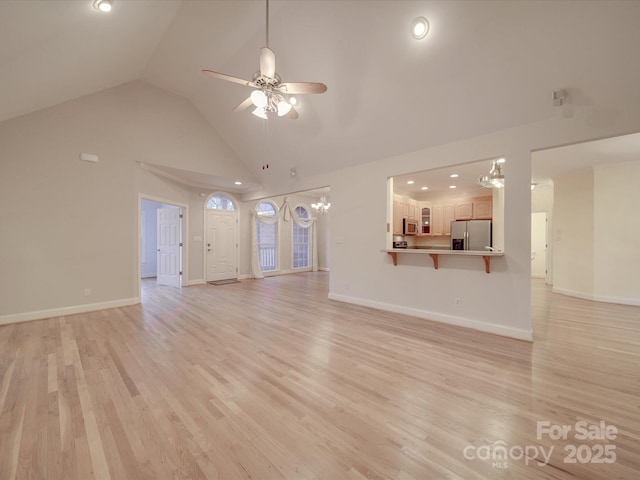 unfurnished living room featuring ceiling fan, vaulted ceiling, and light wood-type flooring