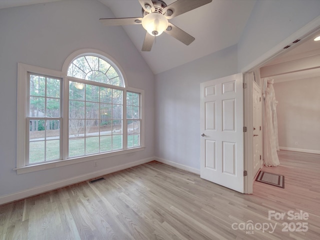 unfurnished room with ceiling fan, vaulted ceiling, and light wood-type flooring