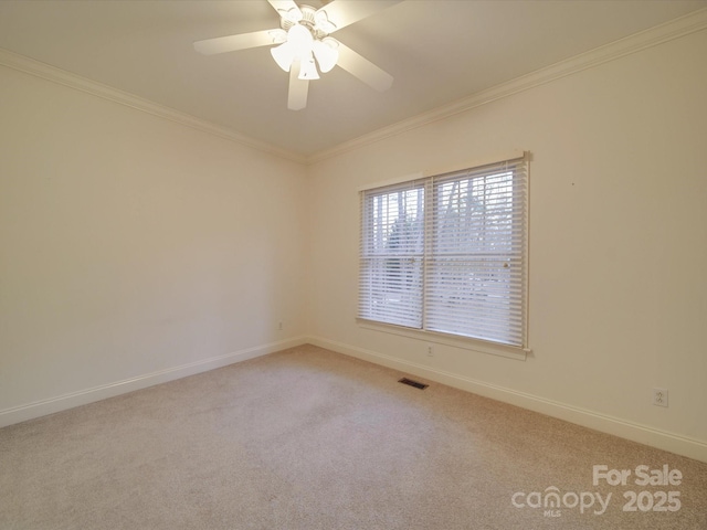 empty room featuring ceiling fan, light colored carpet, and ornamental molding