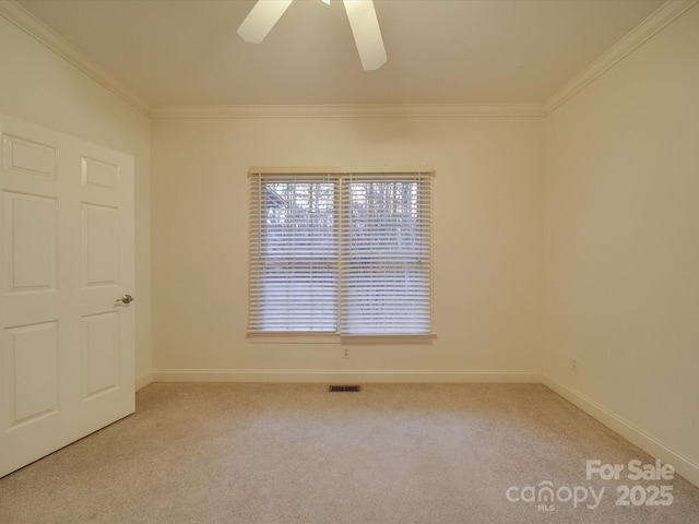 carpeted empty room with ceiling fan and crown molding