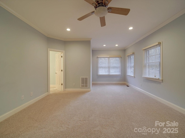 carpeted empty room with ceiling fan and crown molding