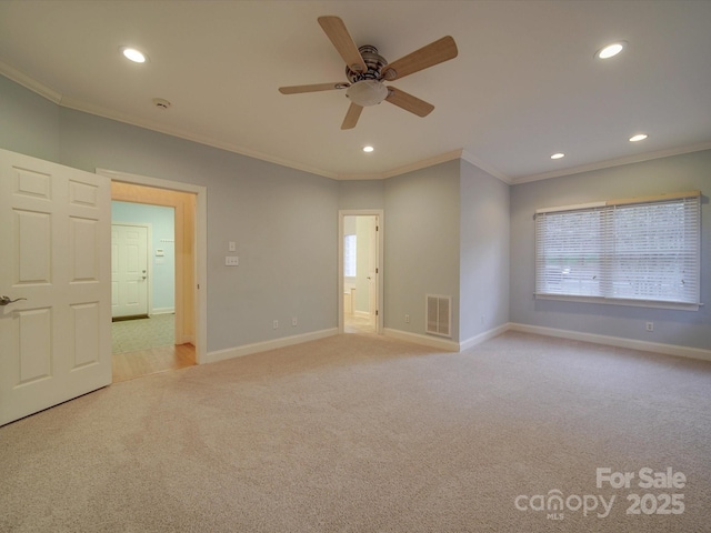 spare room featuring light carpet, ceiling fan, and ornamental molding