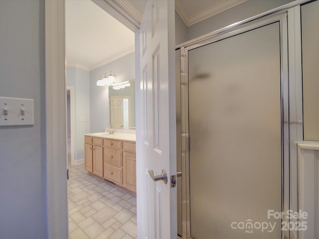 bathroom with vanity, a shower with door, and ornamental molding