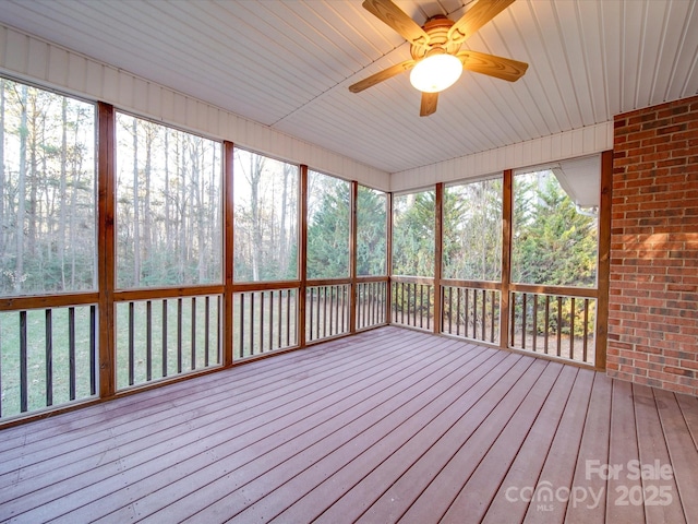 unfurnished sunroom with ceiling fan