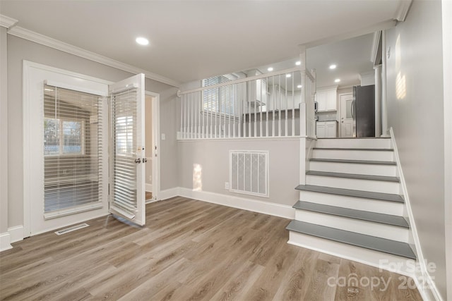 foyer featuring light hardwood / wood-style floors and crown molding