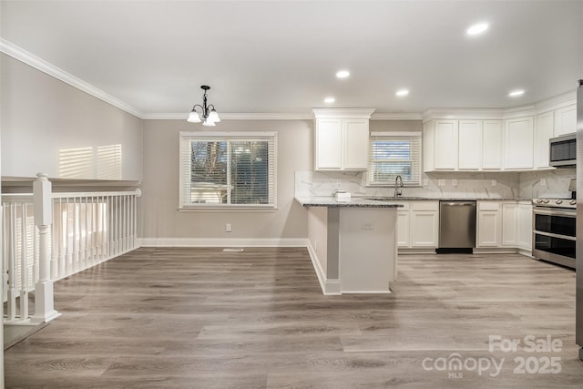 kitchen featuring white cabinetry, light stone counters, a notable chandelier, decorative backsplash, and appliances with stainless steel finishes