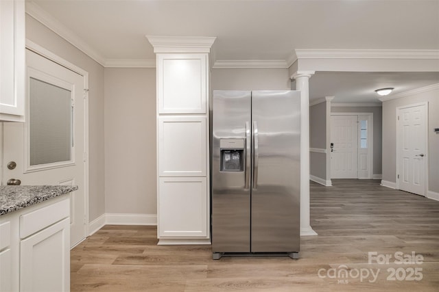 kitchen with crown molding, stainless steel fridge with ice dispenser, light stone countertops, light hardwood / wood-style floors, and white cabinetry