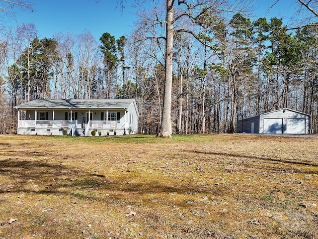 exterior space featuring a porch, a garage, an outbuilding, and a front lawn