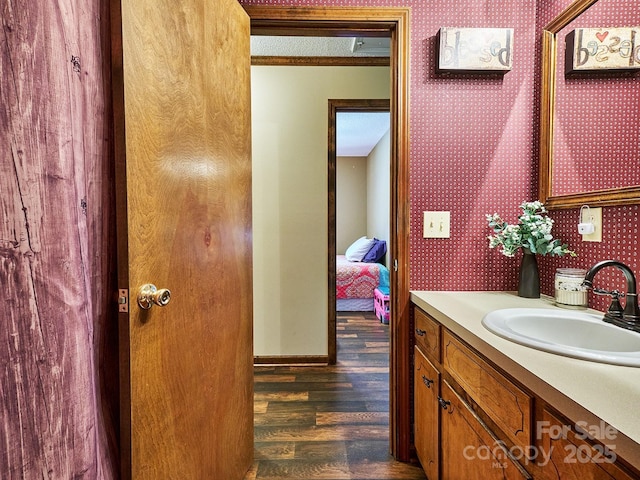 bathroom featuring crown molding, hardwood / wood-style floors, vanity, and a textured ceiling