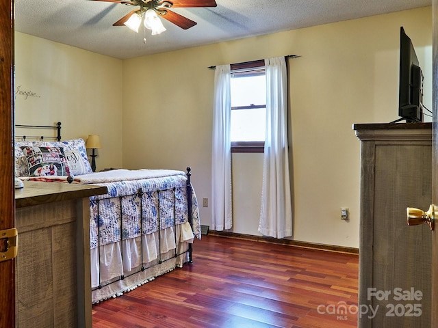 bedroom featuring a textured ceiling, ceiling fan, and dark wood-type flooring