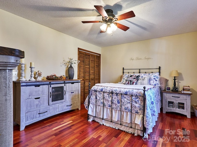 bedroom featuring ceiling fan, dark hardwood / wood-style floors, a textured ceiling, and a closet