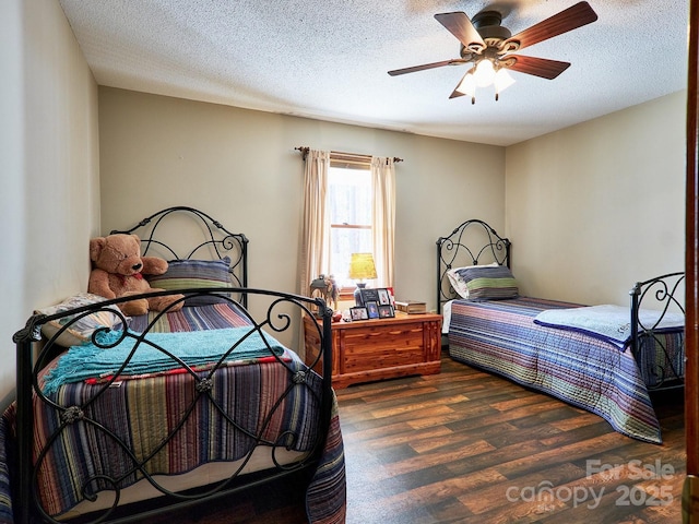 bedroom featuring a textured ceiling, dark hardwood / wood-style floors, and ceiling fan