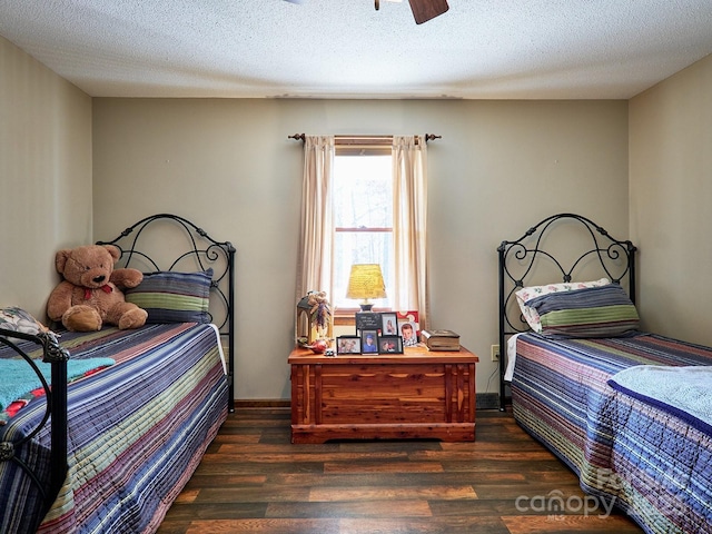 bedroom featuring ceiling fan, dark wood-type flooring, and a textured ceiling