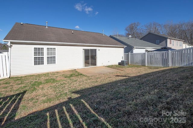 back of property with a patio area, central air condition unit, and a yard