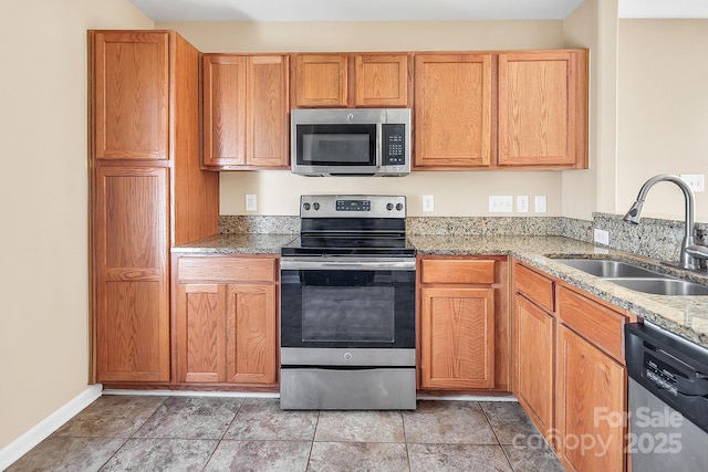 kitchen with light stone countertops, light tile patterned floors, stainless steel appliances, and sink