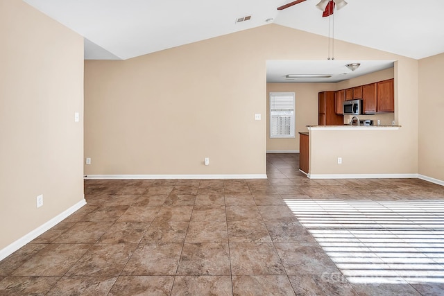 unfurnished living room featuring ceiling fan and vaulted ceiling