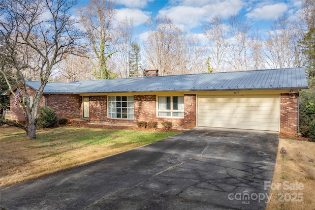 single story home featuring a garage and a front lawn