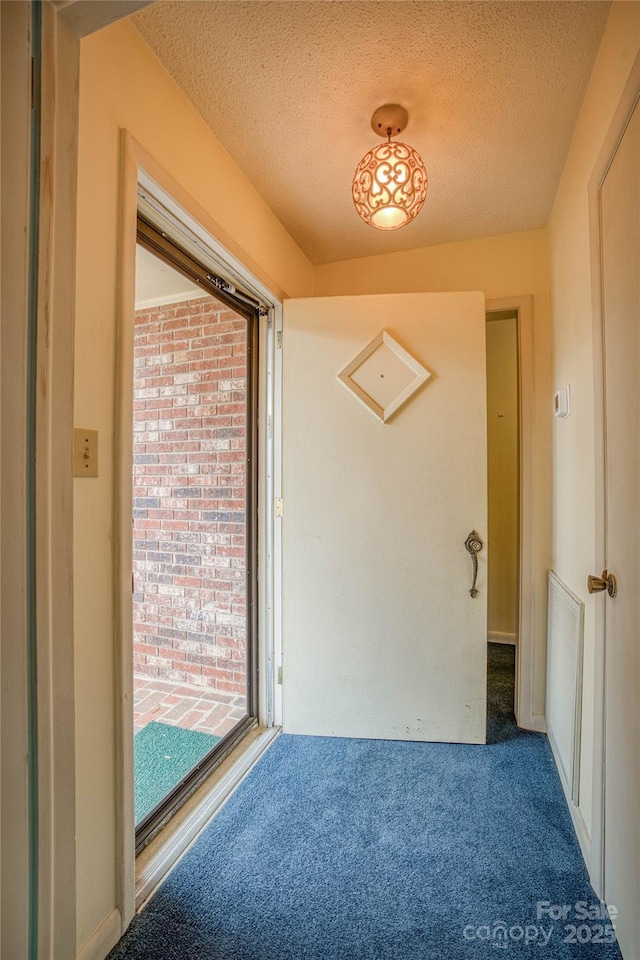 interior space featuring a textured ceiling and carpet floors