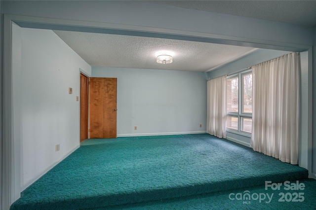 carpeted empty room with a textured ceiling