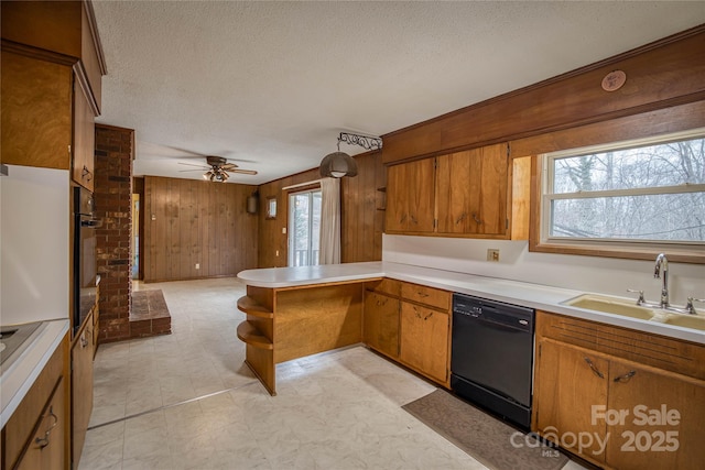 kitchen with ceiling fan, a healthy amount of sunlight, kitchen peninsula, wooden walls, and black appliances