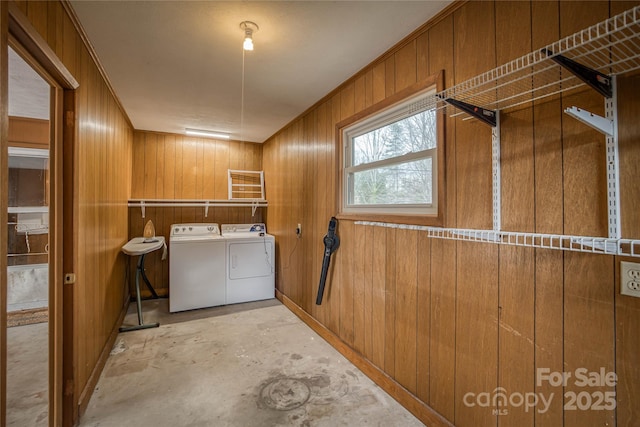 laundry room with separate washer and dryer, crown molding, and wood walls