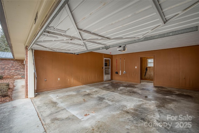 garage featuring a garage door opener and wood walls