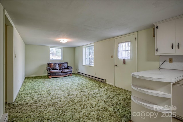 unfurnished room with carpet floors and a baseboard heating unit