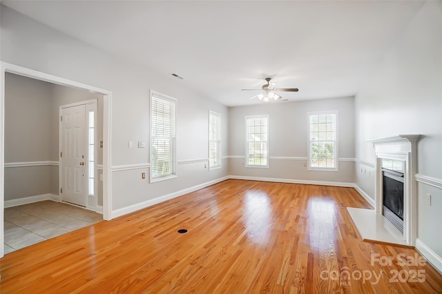 unfurnished living room featuring ceiling fan and light wood-type flooring