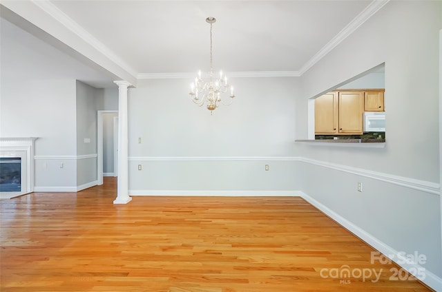 unfurnished dining area with an inviting chandelier, light hardwood / wood-style floors, and ornamental molding