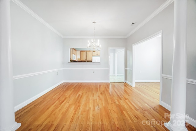 unfurnished dining area featuring light hardwood / wood-style floors, crown molding, and a notable chandelier