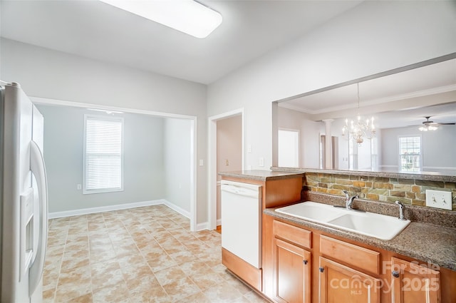 kitchen with white appliances, ceiling fan with notable chandelier, crown molding, sink, and hanging light fixtures