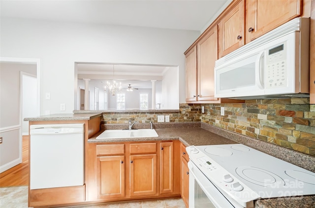 kitchen with white appliances, backsplash, ceiling fan with notable chandelier, sink, and hanging light fixtures