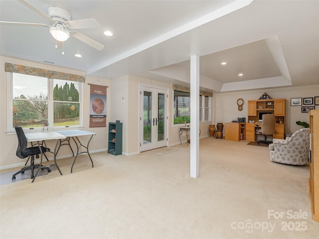 carpeted office featuring french doors, a raised ceiling, and ceiling fan