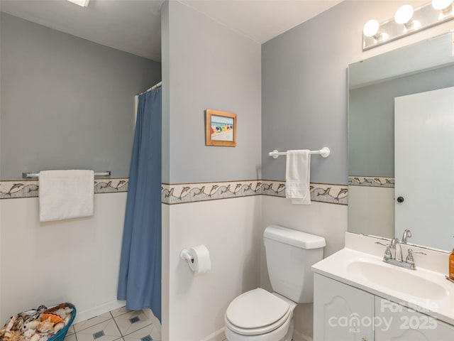 bathroom featuring tile patterned floors, vanity, and toilet