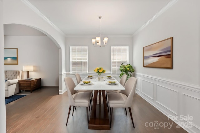 dining room with crown molding, dark wood-type flooring, and a chandelier