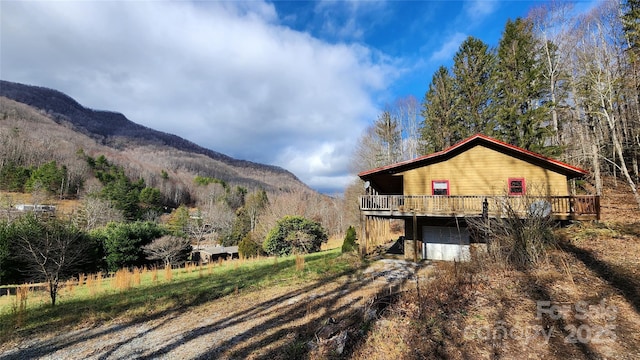 exterior space with a deck with mountain view and a garage