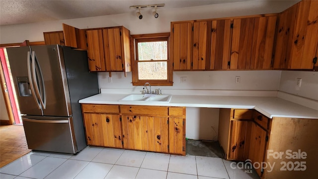 kitchen featuring sink, stainless steel fridge with ice dispenser, a textured ceiling, and light tile patterned floors