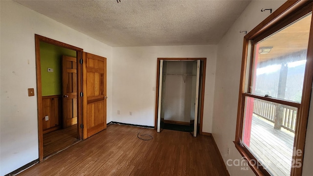 unfurnished bedroom featuring a textured ceiling, hardwood / wood-style floors, and a closet