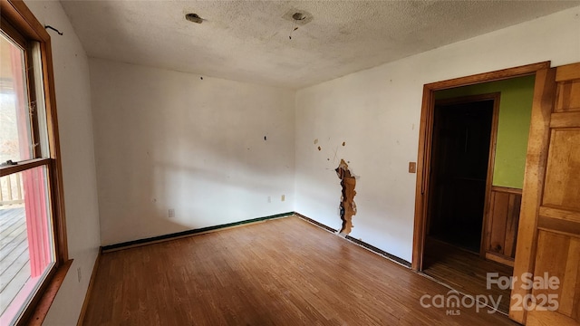 empty room featuring a textured ceiling and hardwood / wood-style flooring